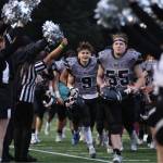 Seniors Payton Grant (9) and TJ Womack (55) jog off the field following a win against East that sent the Huskies to the ASAA Division I First National Bowl. (Ben Hohenstatt / Juneau Empire File)