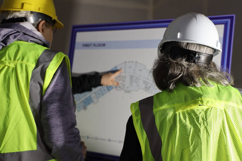 Clarise Larson / Juneau Empire
People look at a set of designs of the Riverview Senior Living facility at a meet and greet at the construction site Friday evening where people could walk through the area and see where construction is at.