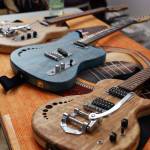 A line up of handmade guitars lie at one of the booths featured at Saturday morning Pumpkin Spice Market. The creator of the guitars, Juneau resident George Gress, said he makes a new guitar around every 11 days, and each one is made from Southeast Alaska wood, hand created by him and dyed or coated with only natural material. (Clarise Larson / Juneau Empire)