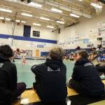 A group of Thunder Mountain High School wrestlers sit along the mat as they watch a match Saturday afternoon during the Brandon Pilot Invitational Wrestling Tournament at THMS. (Clarise Larson / Juneau Empire)