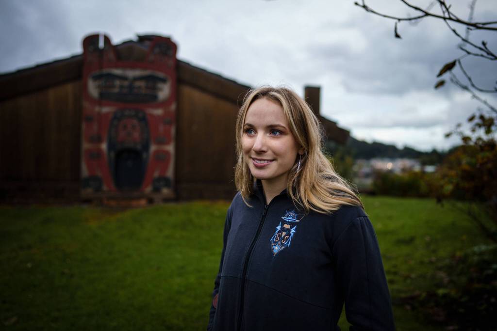 Mia, the author, stands in front of the Chief Shakes Clan House in Wrangell. Photo by Bethany Sonsini Goodrich, Sustainable Southeast Partnership.
