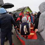 Children sit in a dugout canoe Wednesday in the Southeast Alaska village of Angoon. The dugout was dedicated to mark the 140th anniversary of the bombardment of Angoon. In 1882, the U.S. Navy opened fire on Angoon, burning the village and destroying all but one in its fleet of canoes. The new dugout was carved by Tlingit master carver Wayne Price and students in the Chatham School District. (Clarise Larson / Juneau Empire)