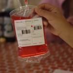 Cheer coach Carlene Nore shows off some of the refreshments served at the JDHS Spirit of Fall Carnival with fruit punch served inside blood bags. (Jonson Kuhn / Juneau Empire)