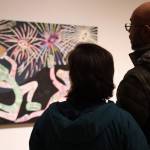 A couple looks at Alison Bremner Nax̲shag̲eits piece Midnight at the Fireworks Stand featured in her solo exhibit on Friday evening at the Alaska State Museum. (Clarise Larson / Juneau Empire)