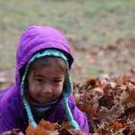 Alex Easton lands into a pile of leaves Tuesday morning at the Evergreen Cemetery. The leaf pile is an annual event organized by Linda Torgerson and has been happening in Juneau for around 25 years. (Clarise Larson / Juneau Empire)