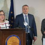 Alaska Attorney General Treg Taylor, center, is seen at a March 2022 news conference featuring Alaska Division of Elections director Gail Fenumiai (left) and deputy attorney general Cori Mills (right). A group that lists Taylor as a director has published a series of scathing attack ads in the last days before the general election. (Photo by Yereth Rosen / Alaska Beacon)