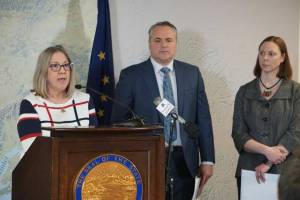 Alaska Attorney General Treg Taylor, center, is seen at a March 2022 news conference featuring Alaska Division of Elections director Gail Fenumiai (left) and deputy attorney general Cori Mills (right). A group that lists Taylor as a director has published a series of scathing attack ads in the last days before the general election. (Photo by Yereth Rosen / Alaska Beacon)