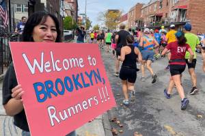 Courtesy Photo / Mary Rozell 
A woman welcomes runners to Brooklyn during the New York City Marathon on Nov. 6, 2022.