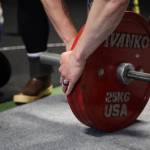 Volunteers add weight to the bar Saturday afternoon at Juneaus Tongass Fitness for a powerlifting competition. (Clarise Larson / Juneau Empire)