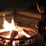 Clarise Larson / Juneau Empire 
X̱unei Lance Twitchell sits next to a fire at a celebration of life ceremony hosted at the University of Southeast Alaskas Noyes Pavilion in honor of late UAS professor Sol Neely Saturday evening.