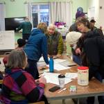 Mark Sabbatini / Juneau Empire 
Organizers coordinate delivery schedules for Thanksgiving food baskets with about 25 teams of volunteers Saturday morning in a community room at St. Vincent de Paul.