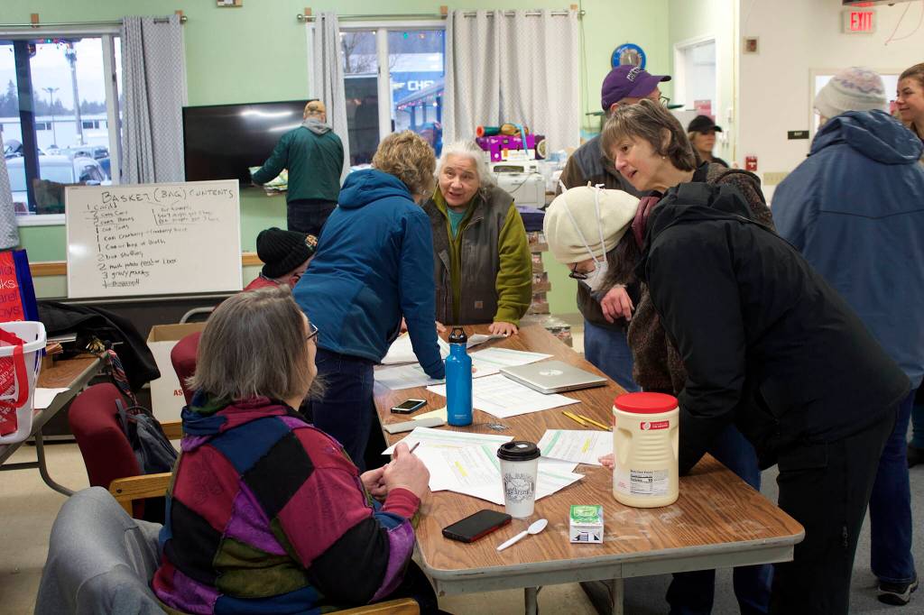 Mark Sabbatini / Juneau Empire 
Organizers coordinate delivery schedules for Thanksgiving food baskets with about 25 teams of volunteers Saturday morning in a community room at St. Vincent de Paul.
