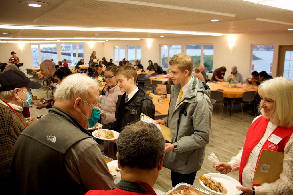 Bruce Botelho, left, and Cathy Munoz serve dinners-to-order during The Salvation Armys annual Thanksgiving meal at the Juneau Yacht Club. They were among the numerous local dignitaries volunteering for the event. (Mark Sabbatini / Juneau Empire)