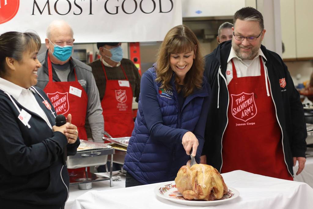 Juneau School District Superintendent Bridget Weiss performs the ceremonial first carving of a turkey at The Salvation Armys annual Thanksgiving Day meal at the Juneau Yacht Club. Weiss, who is retiring next year after a 40-year career in education, said she is thankful her family is in good health and for the people shes interacted with during her time at local schools. (Mark Sabbatini)