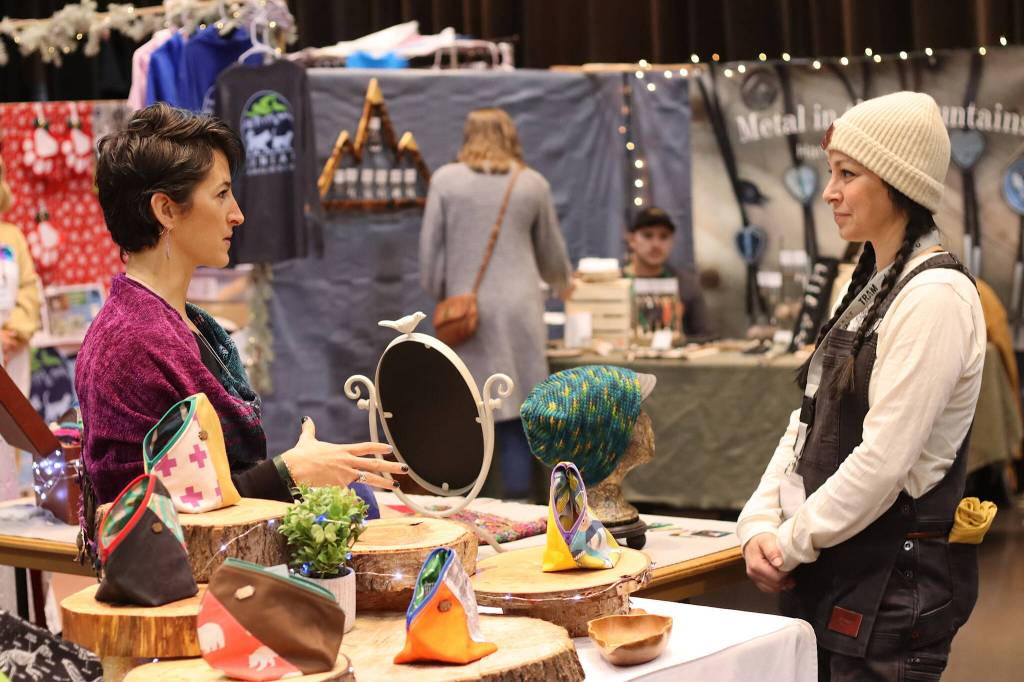 Meg Kelly, an Anchorage resident selling handmade bags and hats, talks to Maria Evans, a Homer resident selling items from her beekeeping company, on Saturday at the Juneau Public Market. In addition to range of longtime and new vendors, the sellers were a mix of Juneau residents and those from elsewhere throughout the U.S. (Mark Sabbatini / Juneau Empire)