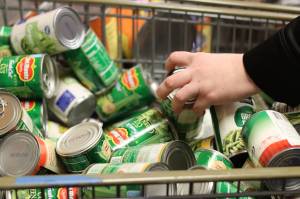 Brittney Fuhr digs through remaining canned goods offered at Helping Hands Food Bank during the pantrys closing day on Friday, Nov. 25. (Jonson Kuhn / Juneau Empire)