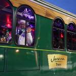 Brett Hutchinson, the driver of the Holiday Trolley, smiles and waves to residents while parked at the Alaska State Library, Archives and Museum Friday evening for the Downtown Business Associations Gallery Walk. (Clarise Larson / Juneau Empire)