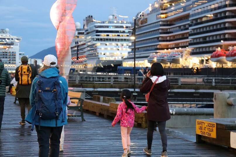Clarise Larson/ Juneau Empire 
People walk the docks as the sun sets in downtown Juneau on Monday night. The City and Borough of Juneau recently signed a memorandum of agreement with member companies of Cruise Lines International Association to come to an agreement on a number of tourism management issue in Juneau.
