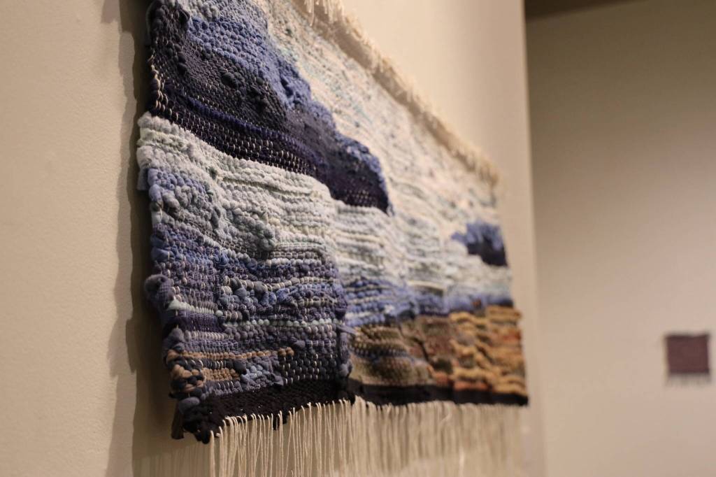 A piece included in Juneau artist Mary McEwens exhibition, Hit & Miss: Adventures in Textile Reuse, hangs on the wall at the Juneau-Douglas City Museum Saturday morning during McEwens Artist Talk. (Clarise Larson / Juneau Empire)