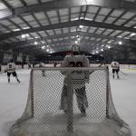 Junior Mason Sooter tends the net as the puck moves to the opposite zone during a home game between Juneau-Douglas High School: Yadaa.at Kalé Crimson Bears Varsity hockey team and the Kenai Central Kardinals at the Treadwell Arena Saturday afternoon. (Clarise Larson / Juneau Empire)