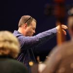 Christopher Koch, music director for the Juneau Symphony, leads the symphonys string section through rehearsal ahead of Juneau Symphonys Holiday Cheer concert. (Ben Hohenstatt / Juneau Empire)