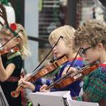 Noah and Caleb Nash along with Iyla Stekoll play for the Juneau Holiday Village on Saturday at the Mendenhall Mall. Juneau Alaska Matters featured musicians from Auke Bay, Kax̱dig̱oowu Héen, and Sitʼ Eeti Shaanax̱ Glacier Valley Elementary schools as well as the Floyd Dryden Middle School seventh and eighth grade orchestras. (Jonson Kuhn / Juneau Empire)