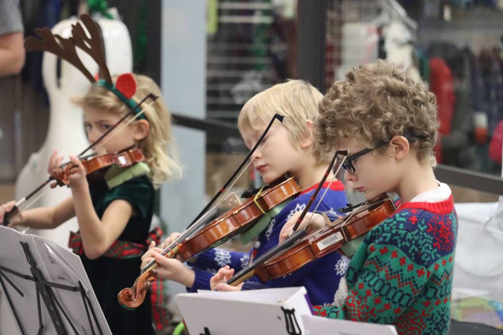 Noah and Caleb Nash along with Iyla Stekoll play for the Juneau Holiday Village on Saturday at the Mendenhall Mall. Juneau Alaska Matters featured musicians from Auke Bay, Kax̱dig̱oowu Héen, and Sitʼ Eeti Shaanax̱ Glacier Valley Elementary schools as well as the Floyd Dryden Middle School seventh and eighth grade orchestras. (Jonson Kuhn / Juneau Empire)
