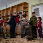 Children traumatized by the war play with an American Pit Bull Terrier Bice in the Center for Social and Psychological Rehabilitation in Boyarka close Kyiv, Ukraine, Wednesday, Dec. 7, 2022. Bice is an American pit bull terrier with an important and sensitive job in Ukraine  comforting children traumatized by the war. The Center for Social and Psychological Rehabilitation is a state-operated community center where a group of people are trying to help those who have experienced a trauma after the Feb. 24 Russian invasion, and now they are using dogs like Bice to give comfort. (AP Photo / Vasilisa Stepanenko)
