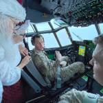 Santa and Mrs. Claus chat with the flight crew of an Alaska National Guard cargo plane while en route to Nuiqsut, Alaska, on Tuesday, Nov. 29, 2022. Operation Santa Claus, the guards outreach program, attempts to bring Santa and Mrs. Claus and gifts to children in two or three Alaska Native villages each year. (AP Photo / Mark Thiessen)