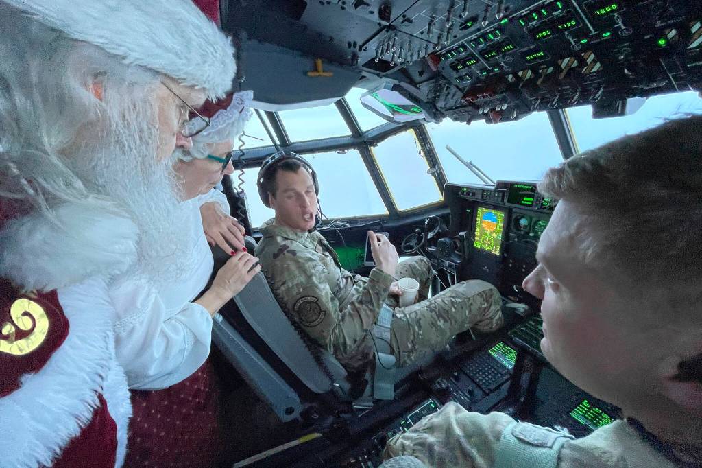 Santa and Mrs. Claus chat with the flight crew of an Alaska National Guard cargo plane while en route to Nuiqsut, Alaska, on Tuesday, Nov. 29, 2022. Operation Santa Claus, the guards outreach program, attempts to bring Santa and Mrs. Claus and gifts to children in two or three Alaska Native villages each year. (AP Photo / Mark Thiessen)