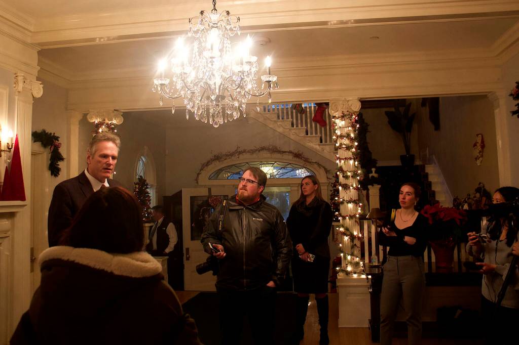 Gov. Mike Dunleavy answers media questions about his proposed budget for next year and the upcoming legislative session shortly before the annual holiday open house at the governors mansion on Tuesday. (Mark Sabbatini / Juneau Empire)