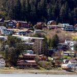 A plane flies in front of a downtown Juneau neighborhood in early May. The City and Borough of Juneau Assembly approved $2 million in funding during the Monday night Assembly meeting toward four affordable housing projects. (Michael S. Lockett / Juneau Empire File)