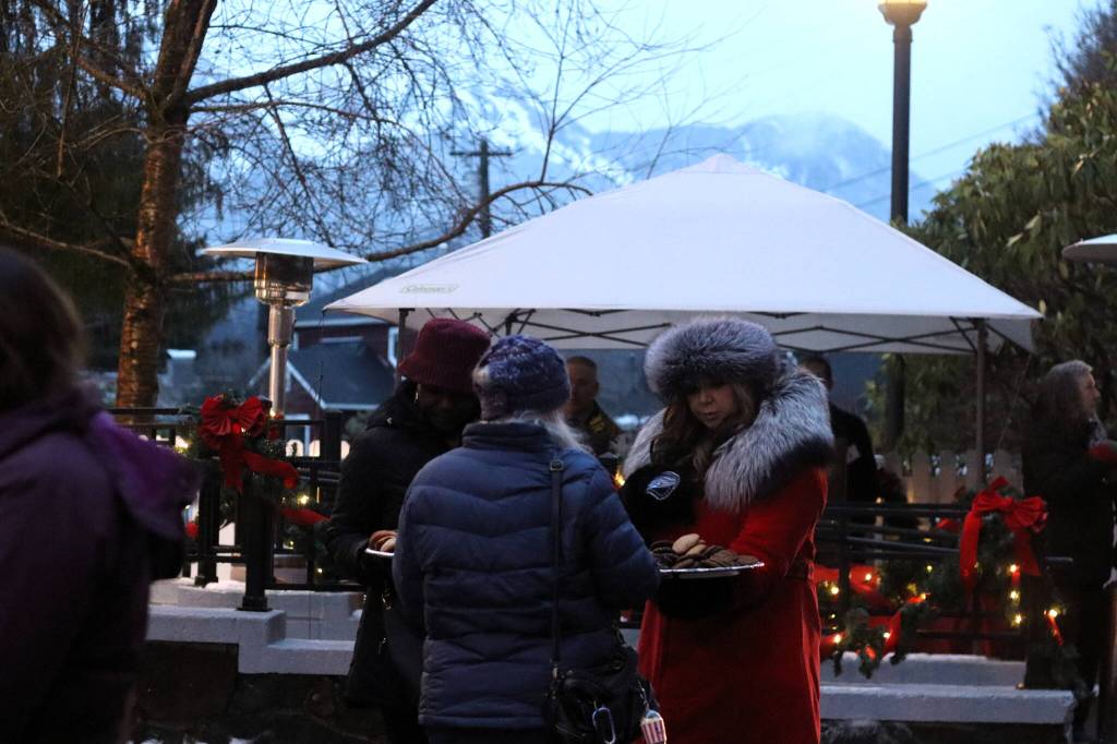 Greeters pass out cookies to people waiting outside during the governors annual holiday open house on Tuesday. (Mark Sabbatini / Juneau Empire)