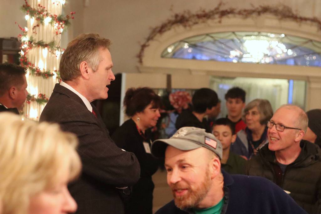Gov. Mike Dunleavy greets visitors to the annual holiday open house at the governors mansion on Tuesday. Hundreds of people indulged in cookies and music by local students during the three-hour event. (Mark Sabbatini / Juneau Empire)