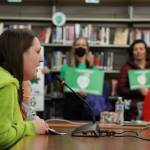 Juneau educator Electra Gardinier holds her young child as she speak to the Juneau School Board Tuesday evening amid its meeting at Thunder Mountain High School. Members and supporters of JEA pushed for better contracts amid drawn-out negotiations. (Clarise Larson / Juneau Empire)