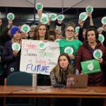 Surrounded by other supporters, Jess Cobley, Juneau Education Association middle school representative at large, speaks to the Juneau District School board about the current status of the contract negotiation cycle between the pair at the boards Tuesday evening meeting at Thunder Mountain High School.(Clarise Larson / Juneau Empire)