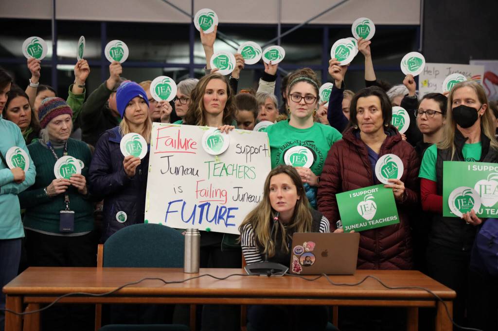 Surrounded by other supporters, Jess Cobley, Juneau Education Association middle school representative at large, speaks to the Juneau District School board about the current status of the contract negotiation cycle between the pair at the boards Tuesday evening meeting at Thunder Mountain High School.(Clarise Larson / Juneau Empire)