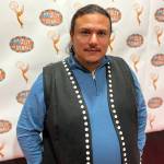 Tlingit playwright and teacher Frank Henry Kaash Katasse poses for a photo on Tuesday during a welcoming home ceremony at Dzantiki Heeni Middle School. Katasse just returned from attending the Emmy Awards where the show he writes for Molly of Denali was nominated for two awards. (Jonson Kuhn / Juneau Empire)