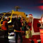 Santa steps off of a helicopter at Juneau International Airport for Christmas Light Flights. This year marked a triumphant return for the event which offers people an aerial view of Juneau during the holiday season. Flying time and staffing are donated by Coastal Helicopters and fuel from Petro Marine Services for the event. (Clarise Larson / Juneau Empire)