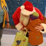 Clarise Larson / Juneau Empire 
Santa hugs Malachi Husemann,5, during Christmas Light Flights at Juneau International Airport.