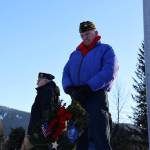 Tom Dawson, a Navy veteran, stands beside a wreath during a laying of wreaths ceremony for National Wreaths Across America Day on Saturday afternoon. (Clarise Larson / Juneau Empire)