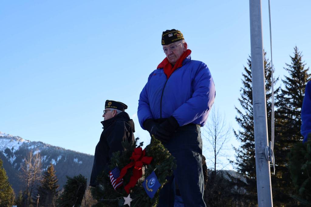 Tom Dawson, a Navy veteran, stands beside a wreath during a laying of wreaths ceremony for National Wreaths Across America Day on Saturday afternoon. (Clarise Larson / Juneau Empire)