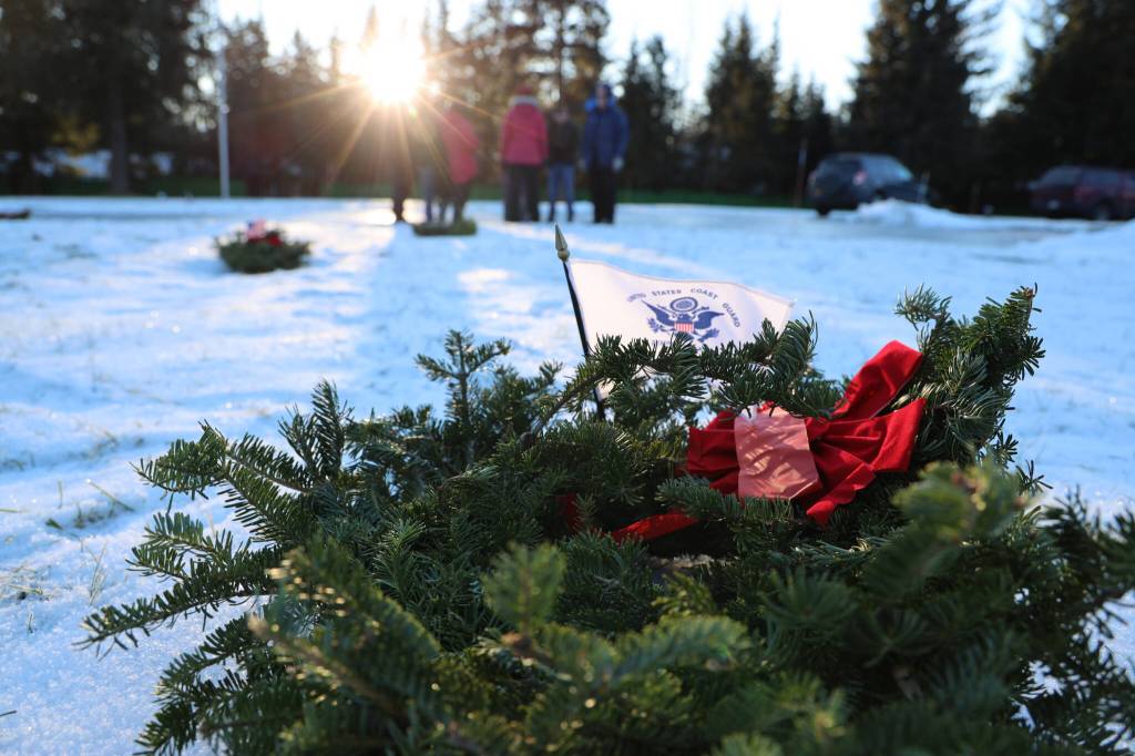 A wreath sits on the ground after being placed during a laying of wreaths ceremony for National Wreaths Across America Day on Saturday afternoon. (Clarise Larson / Juneau Empire)