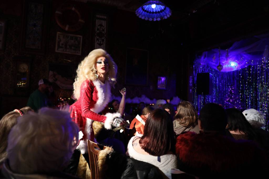 Lamia Monroe accepts a cash tip from a crowd member amid her one of her performances during Juneau Drags two show Holi-gay Spectacular Ho Ho HOMO Saturday evening at the Alaskan Bar. (Clarise Larson / Juneau Empire)