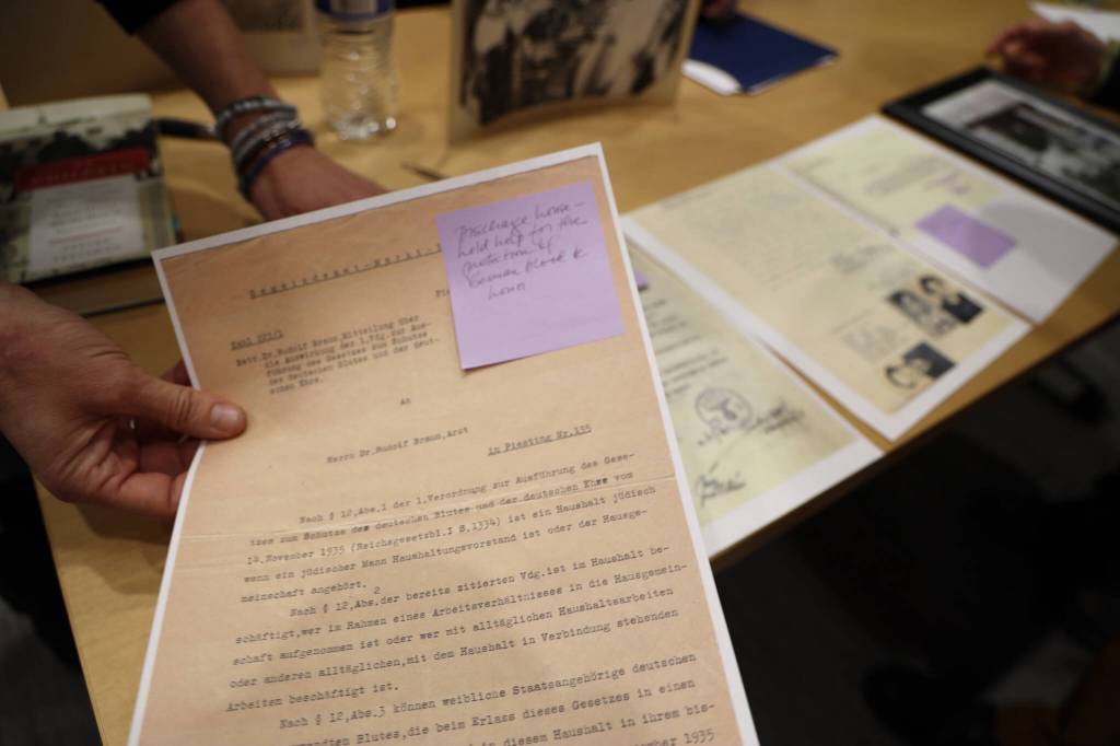 Rebecca Braun shows printed scans of documents her father received from German soldiers before escaping and immigrating to America from Austria before it was annexed by the Nazi regime in 1938. Braun was a speaker at the event, Family Stories  Juneau and the Holocaust, at the Mendenhall Valley Public Library Tuesday evening. (Clarise Larson / Juneau Empire)