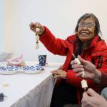 Leona Santiago smiles while holding a beaded key chain made with devils club during a celebration of the winter solstice on Wednesday afternoon at Generations Southeast. According to David Abad, a volunteer at the event who supplied the plant, Devils club often represents protection in Alaska Native cultures. (Clarise Larson / Juneau Empire)