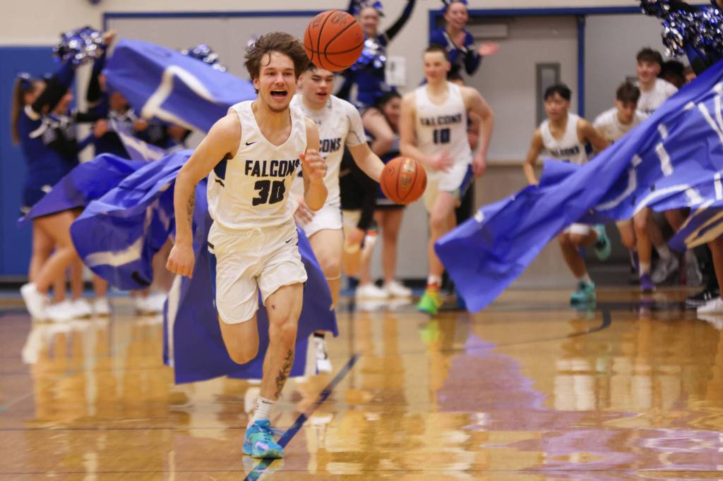 Ben Hohenstatt / Juneau Empire 
Thomas Baxter, a junior, leads the Thunder Mountain High School Falcons through a banner to start the second half of a home win against Petersburg.