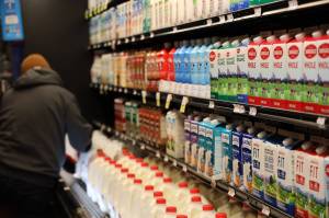 A worker replenishes the dairy goods at Foodland IGA downtown Thursday morning ahead of the holiday weekend and winter storm. Many Juneau stores will be closing their doors to observe the holiday weekend. (Clarise Larson / Juneau Empire)
