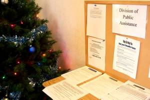 Applications and notifications about changes to benefits line a table at the entrance of the Alaska Division of Public Assistance office in Juneau. The divisions Supplemental Nutrition Assistance Program (SNAP) is months behind processing applications to due to workforce shortages and lingering problems of a cyberattack. (Mark Sabbatini / Juneau Empire)