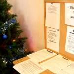 Applications and notifications about changes to benefits line a table at the entrance of the Alaska Division of Public Assistance office in Juneau. The divisions Supplemental Nutrition Assistance Program is months behind processing applications to due to workforce shortages and lingering problems of a cyberattack. (Mark Sabbatini / Juneau Empire)